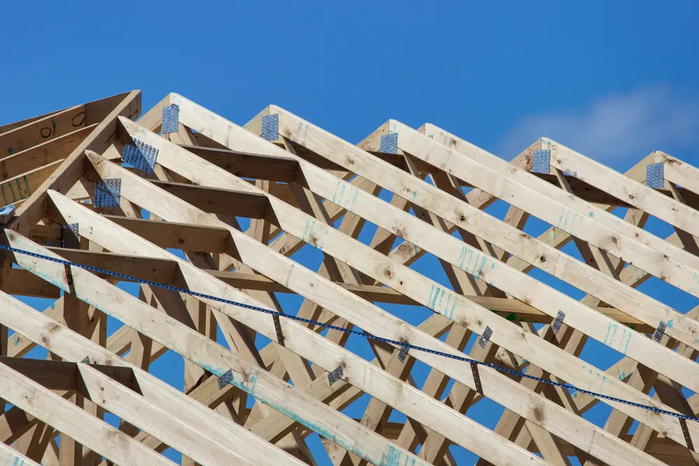 Dachstuhl aus hellem Holz vor blauem Himmel