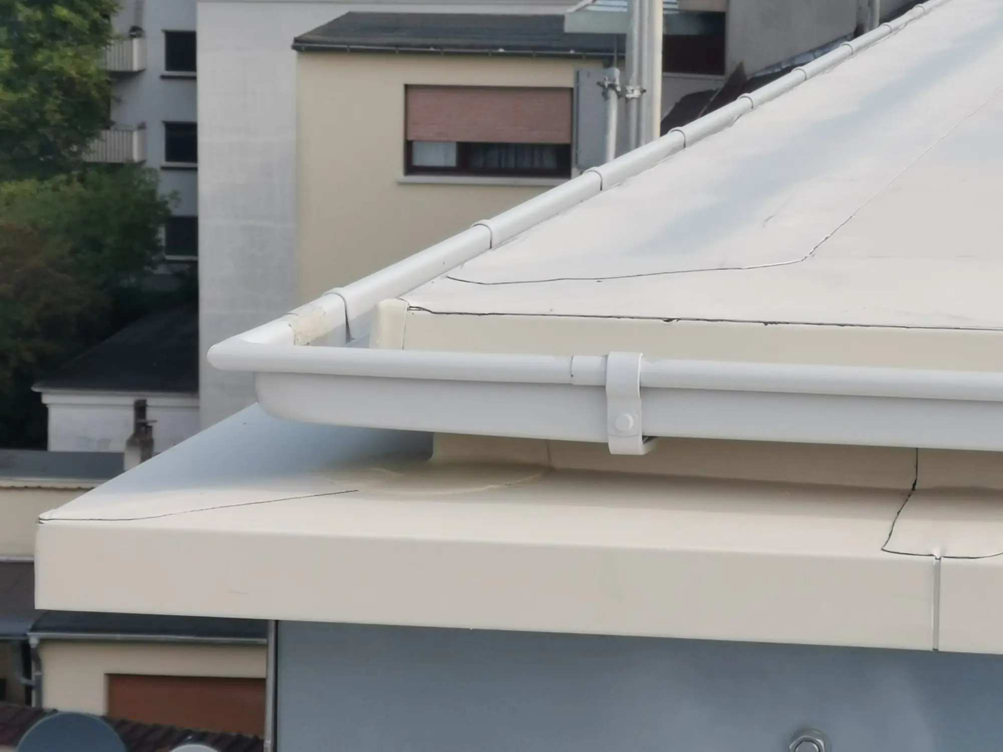 Flachdach mit weißer Dachrinne an einem Mehrfamilienhaus in Mannheim